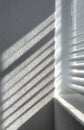 Sunlight creating stripes on textured white wall through blinds Royalty Free Stock Photo