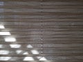 Sunlight falls on fabric blinds in the form of a corrugated sheet with horizontal stripes of gray color. Royalty Free Stock Photo