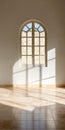 Sunlight filtering through an arched window casts shadows on a tiled floor in a serene interior space Royalty Free Stock Photo