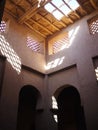 Sunlight filters through the open thatched ceiling of a traditional Arab kasbah. Architecture and interiors in Morocco Royalty Free Stock Photo
