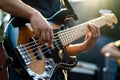 Sunlight illuminates bass players hands creating melodious tunes on glossy instrument