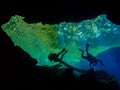 Sunlight illuminates the duckweed as a diver hovers in the cavern at Catfish Hotel in Manatee Springs State Park Royalty Free Stock Photo