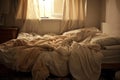 Sunlight is illuminating an unmade bed with rumpled sheets Royalty Free Stock Photo