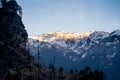 Sunlight lit peaks covered with snow in the distance with tree covered mountains in the foreground in manali Royalty Free Stock Photo