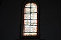 Sunlight pours through the multicolored stained glass in the Church against a dark wall, the interior of the Catholic Cathedral Royalty Free Stock Photo