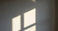 Abstract geometric light patterns created by sunlight streaming through window panes casting warm rectangular shadows onto a cool Royalty Free Stock Photo