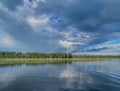 Serene Lake With Rainbow Over Forest Shore Under Dramatic Stormy Sky at Dusk Royalty Free Stock Photo