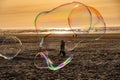 Sunlight refracting through Large colorful bubbles on the ocean coast during sunset.