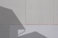 Sunlight and shadow of house structure on surface of gray gypsum wall