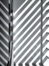 Sunlight and shadow of sunshade battens striped on white cement wall and glass window surface in terrace area