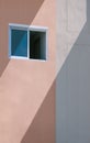 Sunlight and shadow on surface of glass window on pink and white apartment building wall Royalty Free Stock Photo