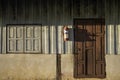 Sunlight and shadow on surface of the old wooden  window and on red wiid door on wood and cement wall background Royalty Free Stock Photo