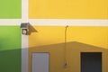 Solar cell spotlight, white door, restroom door with light switch box and pipeline on colorful facade Royalty Free Stock Photo