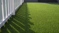 white wooden fence on green artificial turf surface in front yard of home Royalty Free Stock Photo