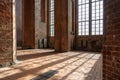 Sunlight shines through the high windows inside the St. Georgen Church, an historic brick building with arches and pillars in the