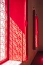 Sunlight shining through with shadow on surface of the old traditional red wooden windows inside of Thai temple