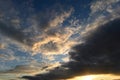 Sunlight in the sky from under the dark clouds at sunset Royalty Free Stock Photo