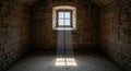 Sunlight streaming through arched window in rustic stone room creating symmetrical warm glow in empty historic setting Royalty Free Stock Photo