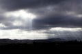 Sunlight Streaming Through Dark Clouds Over Landscape Royalty Free Stock Photo