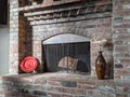 Sunlight streaming in on a wood burning, brick fireplace, surrounded by decor Royalty Free Stock Photo