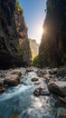 Sunlight streams into a dramatic gorge with a fast-flowing river and rocky canyon walls Royalty Free Stock Photo