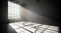 Sunlight streams through industrial windows illuminating an empty room with geometric shadows and dust particles Royalty Free Stock Photo