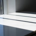 Sunlight streams through a window, casting linear shadows on a smooth, white surface. The light Royalty Free Stock Photo