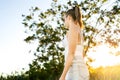 Sunlight in summer field. Woman walking outside in the nature feeling calm and peaceful, good mood. Morning sunshine or evening.