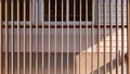 Wooden lath in vertical pattern in front of glass windows with white artificial wood and gray sheetrock background Royalty Free Stock Photo