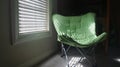 Sunlight thru blinds onto green chair