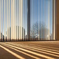 Sunlight through vertical blinds angled slightly open hanging over large sliding interior glass doors