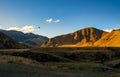 Sunlight warming the hills and mountains as a helicopter flies across the rural farmland Royalty Free Stock Photo