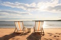 sunlit beach with two empty deck chairs facing the ocean Royalty Free Stock Photo