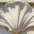 Sunlit Carved Scallop Shell on a Stone Wall Royalty Free Stock Photo