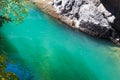 Sunlit emerald whitewater of mountain river