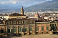 Sunlit facade of Palazzo Pitti, overlooking the Boboli Gardens, beyond the center of Florence silhouetted in the cloudy sky. Royalty Free Stock Photo