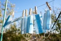 Sunlit face masks are hung to dry for disinfection fastened by wooden clothespins. New normal concept