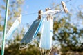 Sunlit face masks are hung to dry for disinfection fastened by wooden clothespins. New normal concept