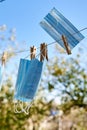 Sunlit face masks are hung to dry for disinfection fastened by wooden clothespins. New normal concept