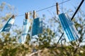 Sunlit face masks are hung to dry for disinfection fastened by wooden clothespins. New normal concept