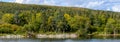 Sunlit fall landscape of the rivers edge and mix of colorful deciduous trees and evergreen trees, Brooks River, Katmai National Pa