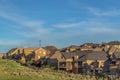 Sunlit homes on a hill with blue sky and thin clouds overhead on a sunny day