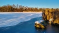 Sunlit landscape at frozen snowy lake