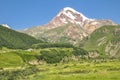 Sunlit mountain Kazbek on blue sky background Royalty Free Stock Photo