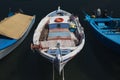 Sunlit Red, White and Blue Mediterranean Weathered Fishing Boat on Water in Euboea - Nea Artaki, Greece Royalty Free Stock Photo