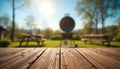 Sunlit rustic wooden table with barbecue grill, picnic benches, and blurred trees background Royalty Free Stock Photo