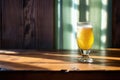sunlit saison beer glass casting a shadow on a wooden table