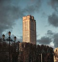 Sunlit skyscraper tower of Madrid at sunset, cloudy sky background