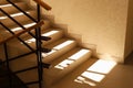 Sunlit staircase with railings in the house. Staircase at the entrance of an apartment building. Modern entrance interior in