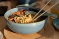 Sunlit Table and Steaming Bowl of Ramen Soup, side view